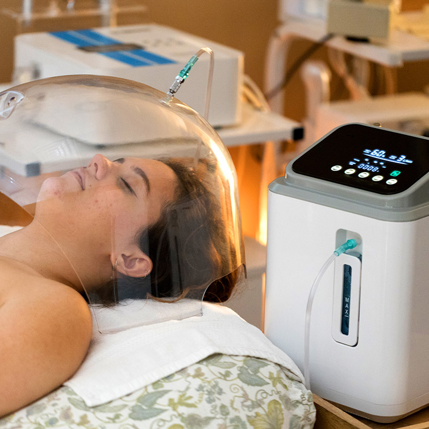 A woman with an oxygen dome over her face receiving an organic skin therapy oxygen facial at Natural Balance Massage Therapy & Wellness Center in Palm Harbor, Florida.